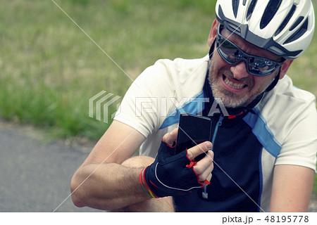 Injured biker holding smartphone calling rescue 48195778