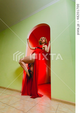 Attractive blonde model in the red dress with high slit and long naked legs Attractive blonde model in the red dress with high slit and long naked legs 48201700