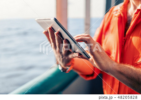 chief officer or captain on deck of vessel or ship watching digital tablet 48205828