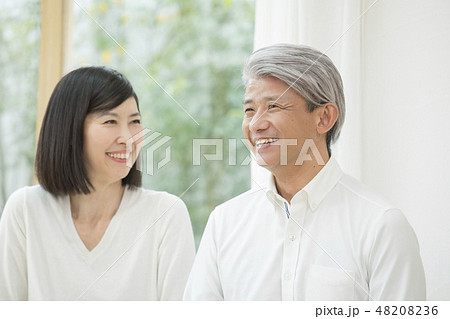 リビングでくつろぐミドル夫婦 48208236