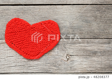 Red knitted heart on a gray wooden background 48208377