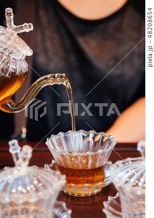 Pouring English black tea into glass tea cup Pouring English black tea into glass tea cup 48208654
