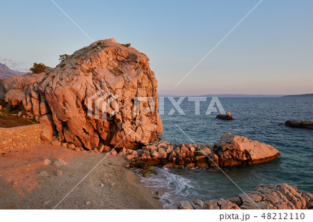 Rock island at sunset in small mediterranean Rock island at sunset in small mediterranean 48212110