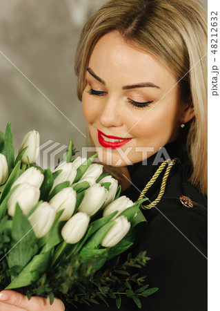 Portrait of beautiful mother hold a bouquet of white tulips on 8th of march. Flowers in woman's hand Portrait of beautiful mother hold a bouquet of white tulips on 8th of march. Flowers in woman's hand 48212632