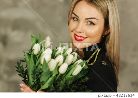 Portrait of beautiful mother hold a bouquet of white tulips on 8th of march. Flowers in woman's hand Portrait of beautiful mother hold a bouquet of white tulips on 8th of march. Flowers in woman's hand 48212634
