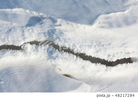 Crack on the snow river in the spring 48217284