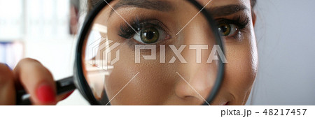 Funny smiling businesswoman hold in arm magnifier Funny smiling businesswoman hold in arm magnifier 48217457