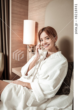 Woman smiling while having phone conversation with old friend Woman smiling while having phone conversation with old friend 48218441