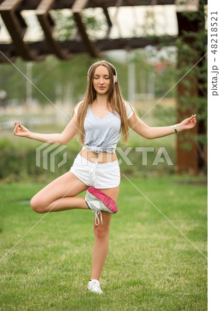 Young sportive girl doing yoga in park in the city 48218521
