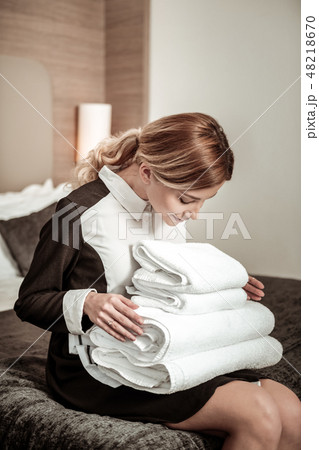 Housekeeper counting white towels before handing them to client Housekeeper counting white towels before handing them to client 48218670