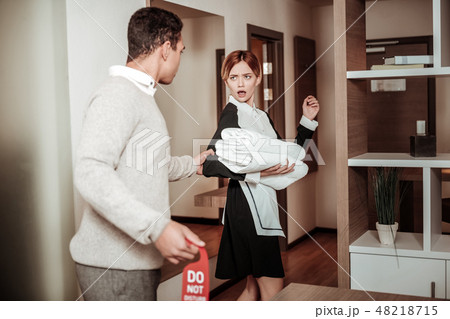 Man grasping arm of housekeeper planning harassing her 48218715