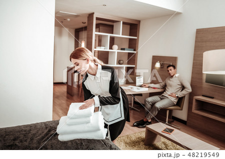 Pleasant hard-working housekeeper bringing new white towels 48219549