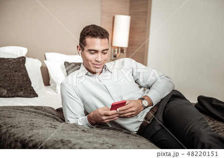 Young businessman wearing nice watch using his red smartphone 48220151