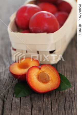 Fresh red plums on wooden background Fresh red plums on wooden background 48220658