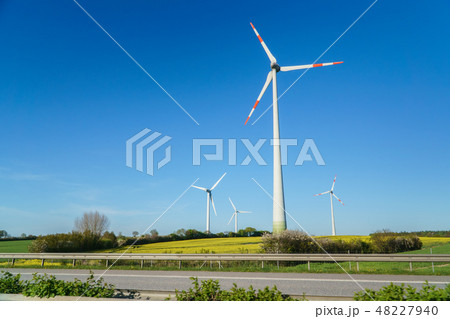 Windmills, Many wind turbines standing on field with lush green grass in spring, alternative energy 48227940
