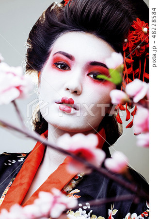 young pretty geisha in black kimono among sakura, asian ethno close up on white background young pretty geisha in black kimono among sakura, asian ethno close up on white background 48228584