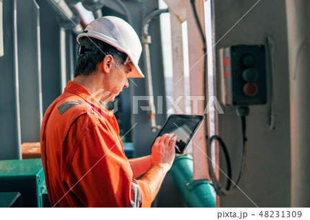 chief officer or captain on deck of vessel or ship watching digital tablet 48231309
