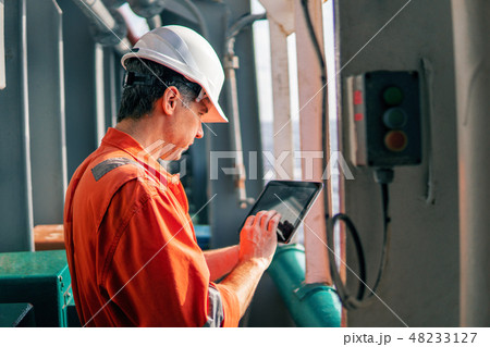chief officer or captain on deck of vessel or ship watching digital tablet 48233127