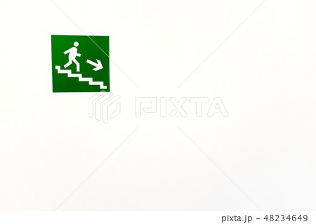 Green sign down the stairs on an empty bright wall 48234649