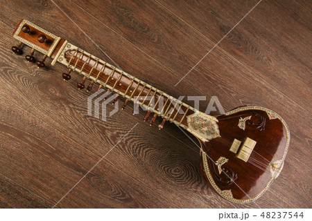 Indian musical instrument sitar lying on the wooden floor Indian musical instrument sitar lying on the wooden floor 48237544
