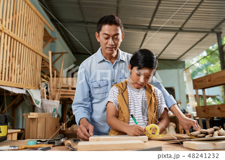 Boy measuring wooden plank 48241232