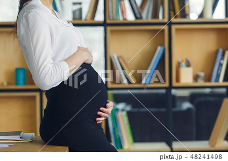 Pregnant business woman working at office motherhood touching belly Pregnant business woman working at office motherhood touching belly 48241498