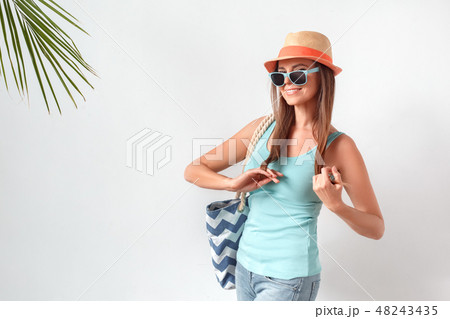 Summertime. Woman in hat and sunglasses standing studio isolated on white with beach bag posing to Summertime. Woman in hat and sunglasses standing studio isolated on white with beach bag posing to 48243435