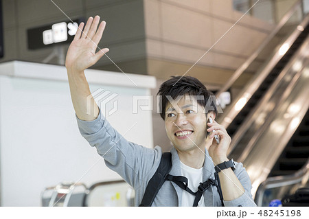 空港で通話しながら手を振る男性　旅行イメージ 48245198