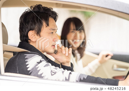 二人初めてのドライブで行先を話し合う可愛い女性と若くてカッコイイ男性の写真素材
