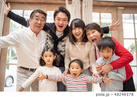 元気いっぱいに手を広げて喜びを表現する笑顔の仲良し大家族の写真素材