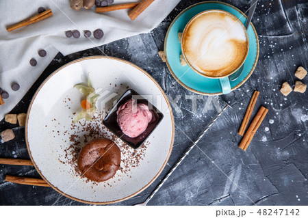 Chocolate lava cake Molten with ice cream on plate and cappuccino. Balls of ice cream in cup . Dark Chocolate lava cake Molten with ice cream on plate and cappuccino. Balls of ice cream in cup . Dark 48247142