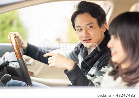 俺のどこが好き 車を運転しながらキザなセリフを助手席の彼女に問いかけるイケメン俳優の写真素材