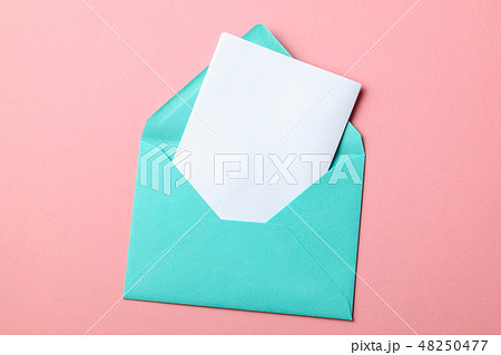 Green envelope and blank letter on pink background 48250477