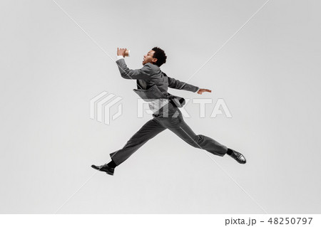 Happy businessman dancing isolated on gray studio background Happy businessman dancing isolated on gray studio background 48250797