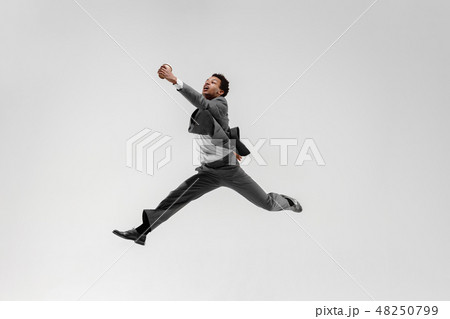 Happy businessman dancing isolated on gray studio background Happy businessman dancing isolated on gray studio background 48250799