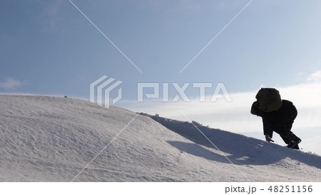 climbers hand in hand climb to top of a snowy mountain. the team of travelers in winter go to their climbers hand in hand climb to top of a snowy mountain. the team of travelers in winter go to their 48251156