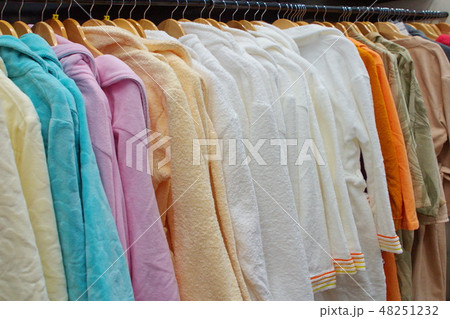 Image of many colorful bathrobes on wooden hangers in the store Image of many colorful bathrobes on wooden hangers in the store 48251232
