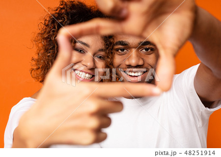 Black man and woman show frame sign with hands 48251914