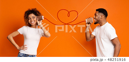 Young black couple with can phone on orange background 48251916