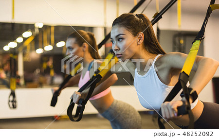 Women training arms with trx fitness straps Women training arms with trx fitness straps 48252092