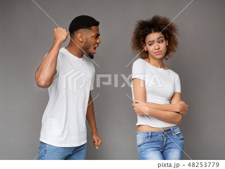 Young man threatening his girlfriend with his fist Young man threatening his girlfriend with his fist 48253779