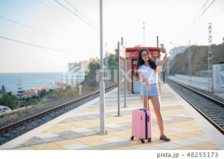 Young Happy Asian Tourist Woman Taking Selfie At The Train Station Young Happy Asian Tourist Woman Taking Selfie At The Train Station 48255173