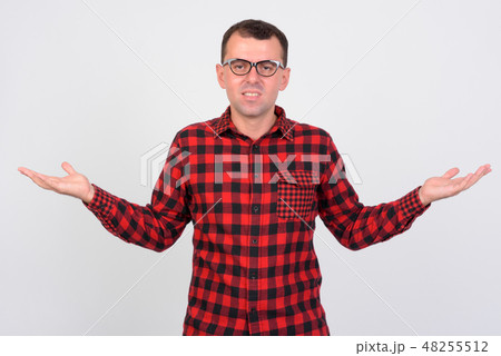 Portrait of confused hipster man shrugging shoulders Portrait of confused hipster man shrugging shoulders 48255512