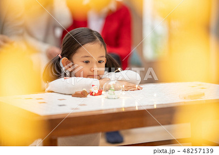 サンタクロースからのクリスマスプレゼントを待ち望んでいる幼稚園年長可愛い女の子5歳とイルミネーション 48257139