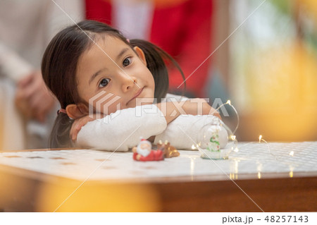 サンタクロースからのクリスマスプレゼントを待ち望んでいる幼稚園年長可愛い女の子5歳とイルミネーション 48257143
