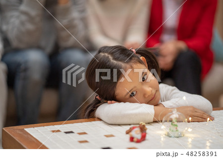 サンタクロースからのクリスマスプレゼントを待ちわびている幼稚園児の可愛い女の子 48258391