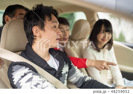 記念日に実家に帰省し高齢の両親を笑顔で旅行ドライブに連れていく仲の良い新婚夫婦男女家族四人 48259052