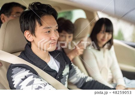 記念日に実家に帰省し高齢の両親を笑顔で旅行ドライブに連れていく仲の良い新婚夫婦男女家族四人 48259053