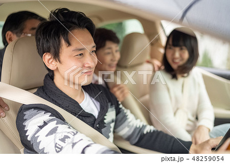 記念日に実家に帰省し高齢の両親を笑顔で旅行ドライブに連れていく仲の良い新婚夫婦男女家族四人 48259054