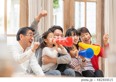 オリンピックをテレビ観戦し六人家族全員で応援する幸せそうな三世代家族の写真素材